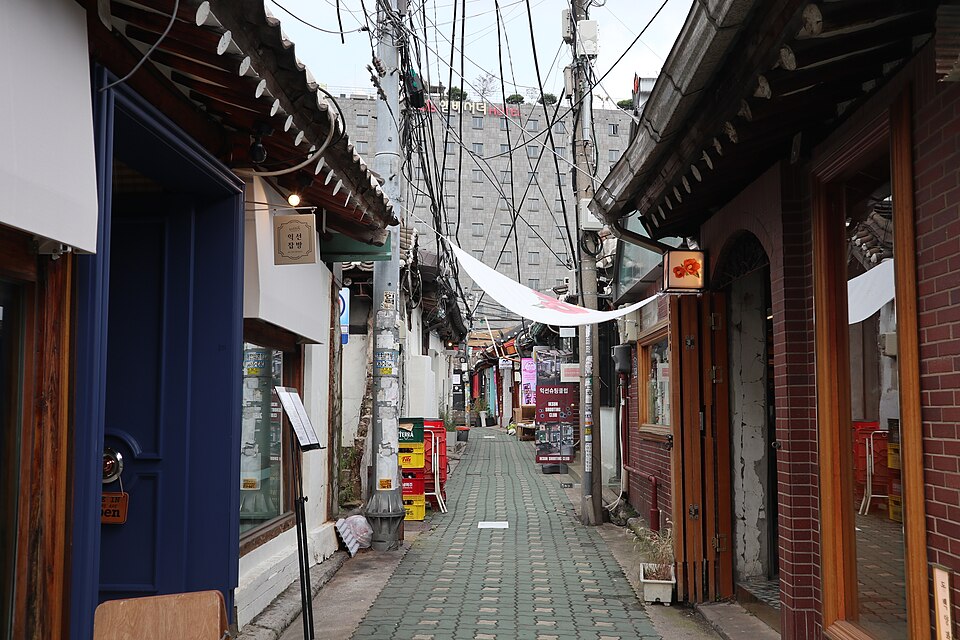 A narrow alley in Ikseon-dong lined with small shops and cafés in old low buildings